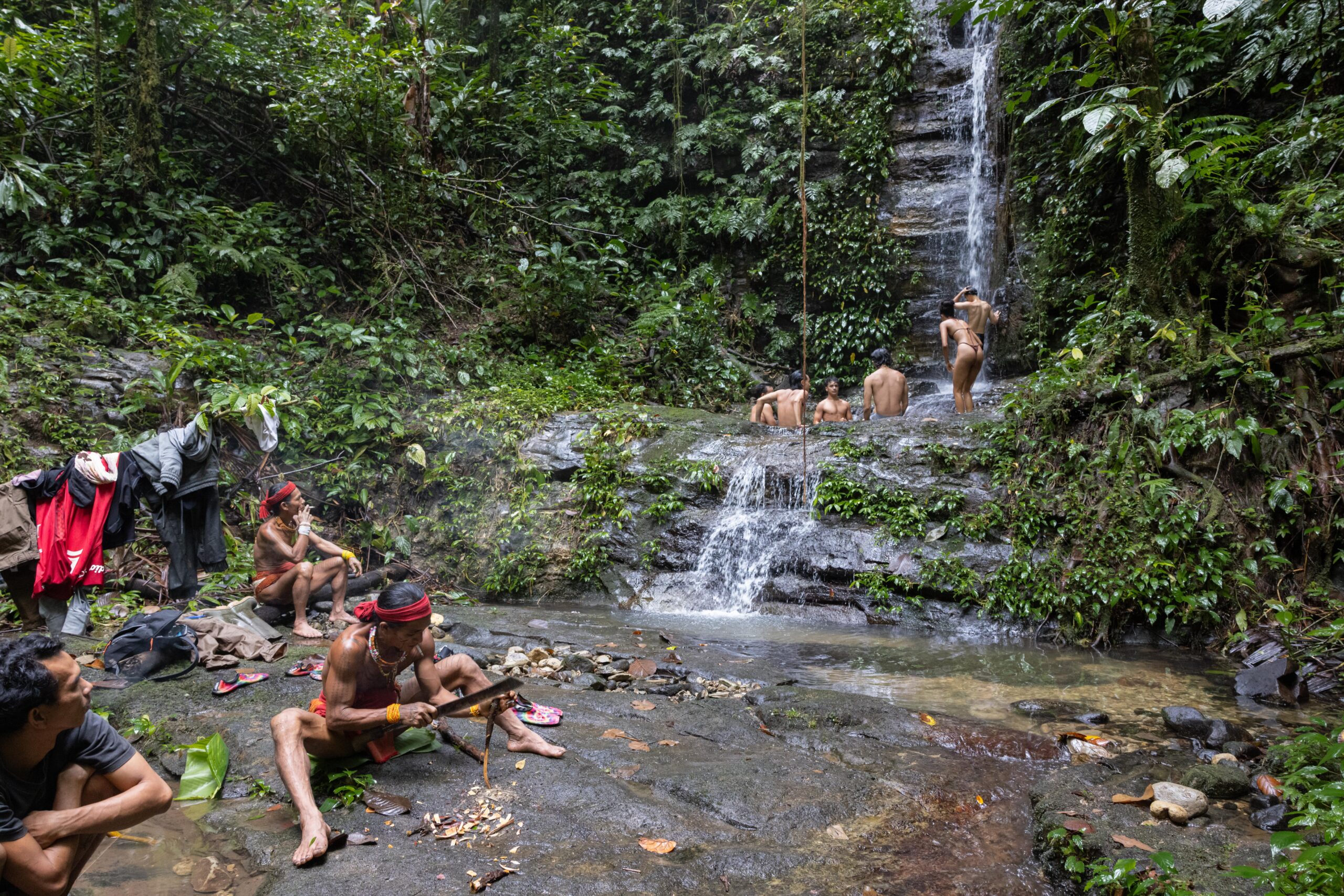 Tourists visiting a waterfall in the rainforest of Siberut Island