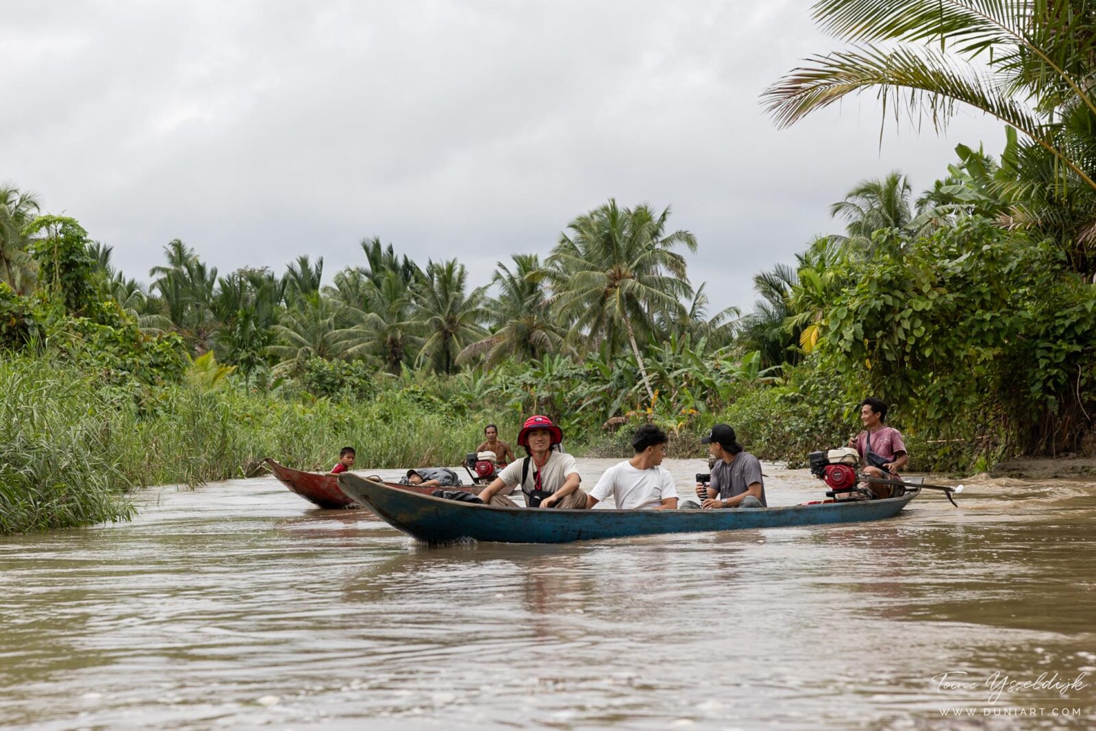 Tourists traveling by canoe through the rainforest on Siberut Island