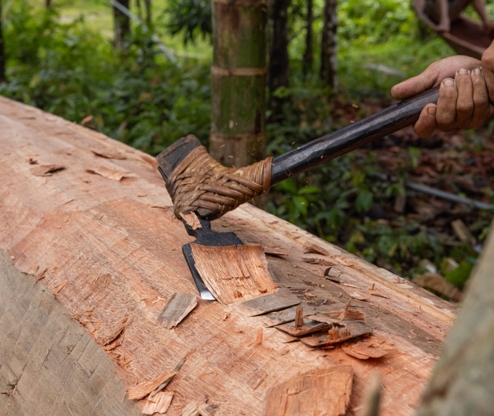 A Mentawai man shaping a canoe with an adze on Siberut Island