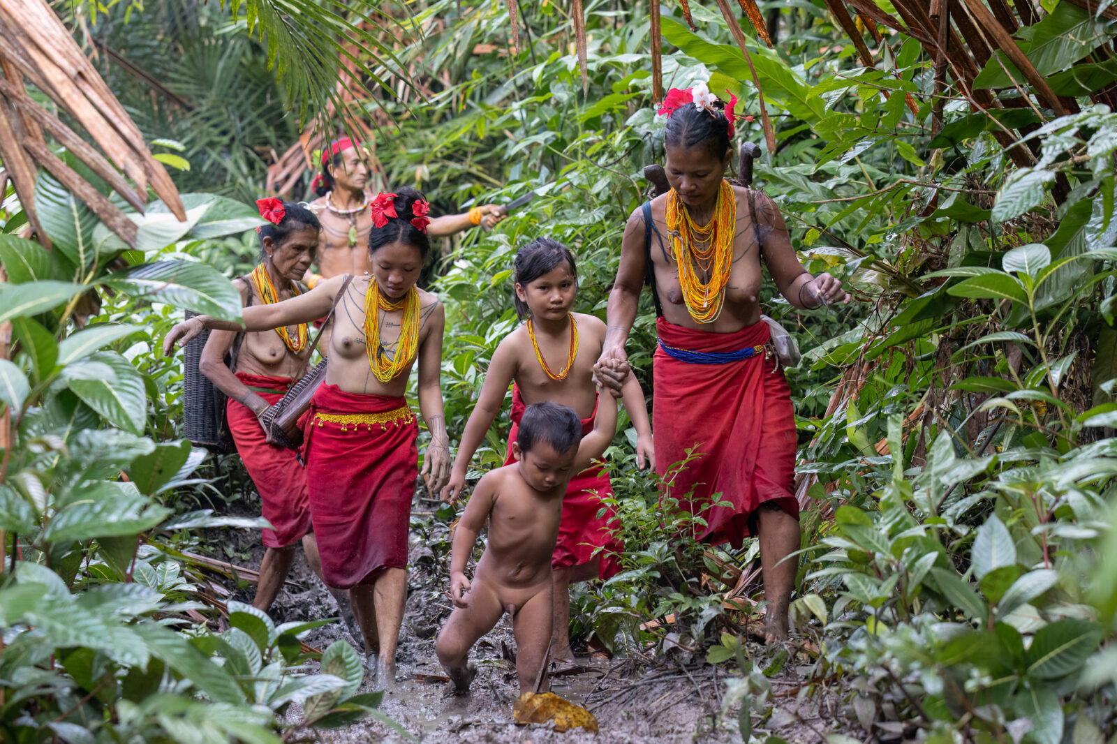 Mentawai family walking in rainforest Siberut island