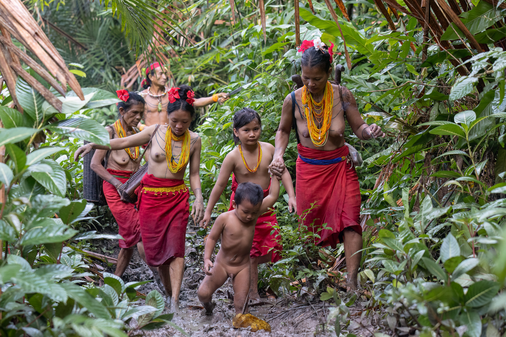 Mentawai family walking in rainforest Siberut island