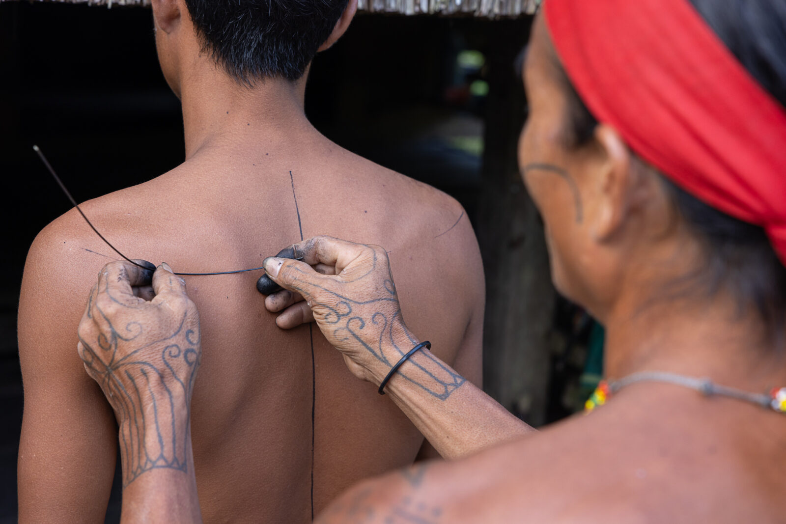 Mentawai hand-tapping tattoo process on back