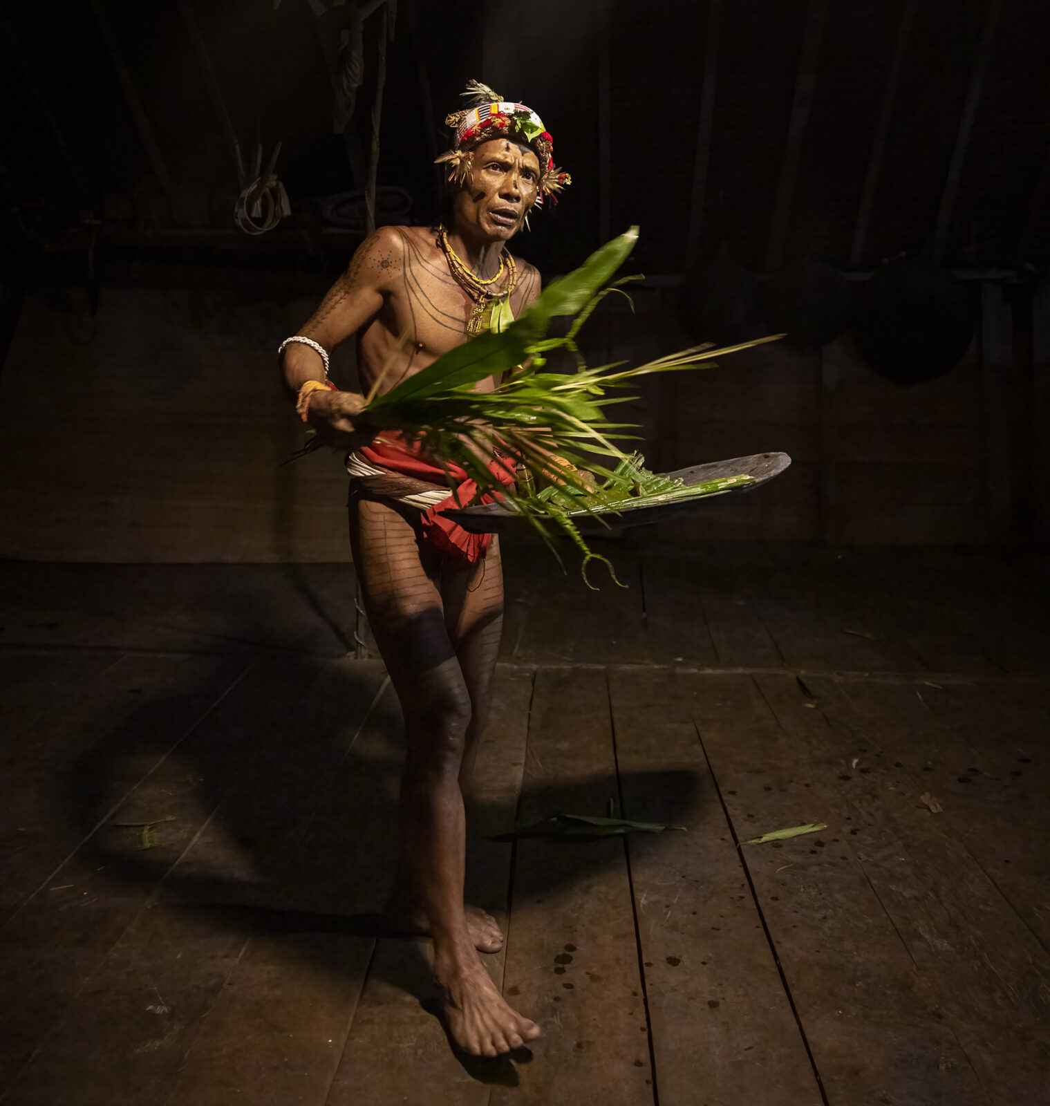 Mentawai shaman with leaves during pasibitbit uma house cleansing ritual