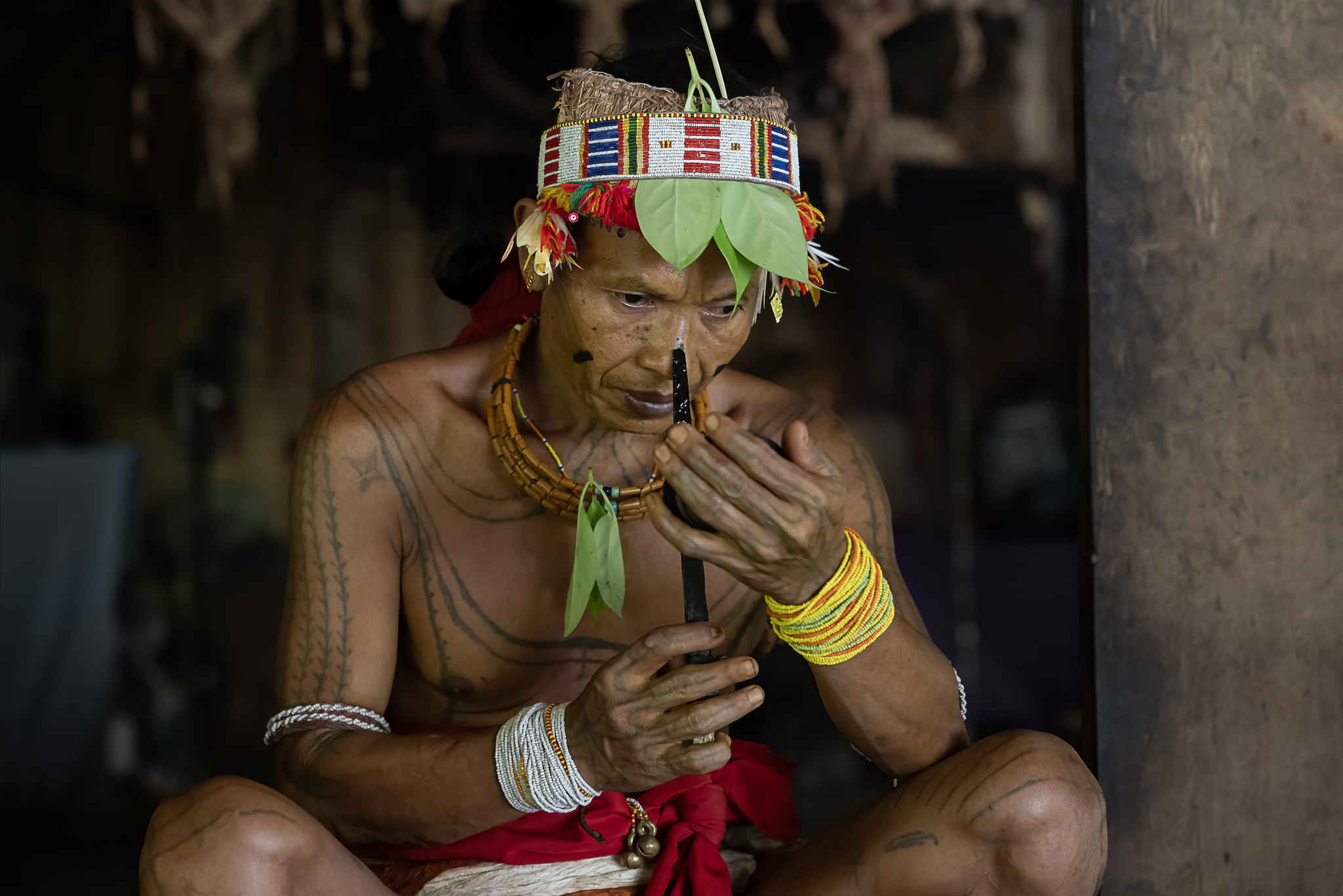 Indigenous man holding a mirror.