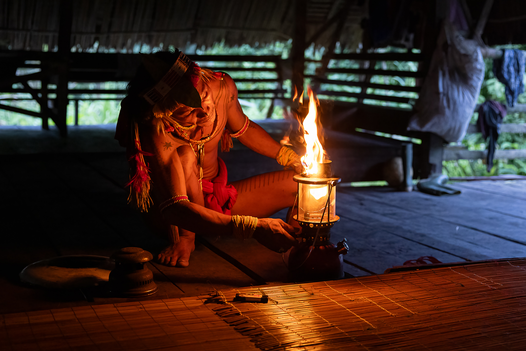 Mentawai shaman lighting a kerosine pressure lamp