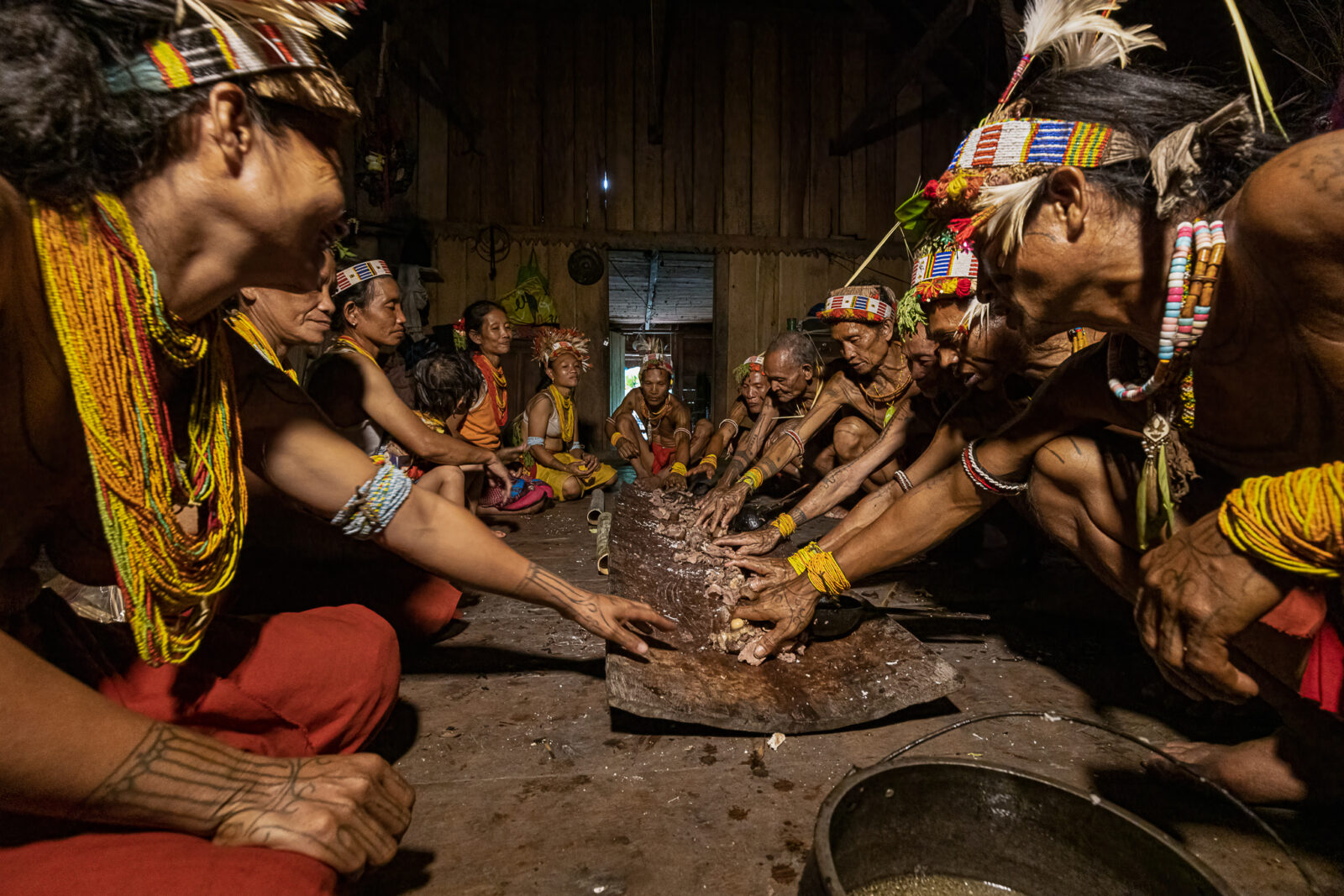 Mentawai shamans and wives at pululak ritual meal during ceremony