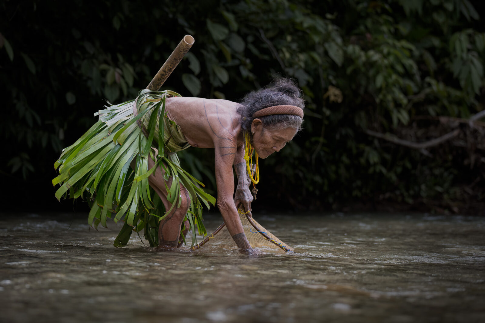Mentawai woman fishing in river with net