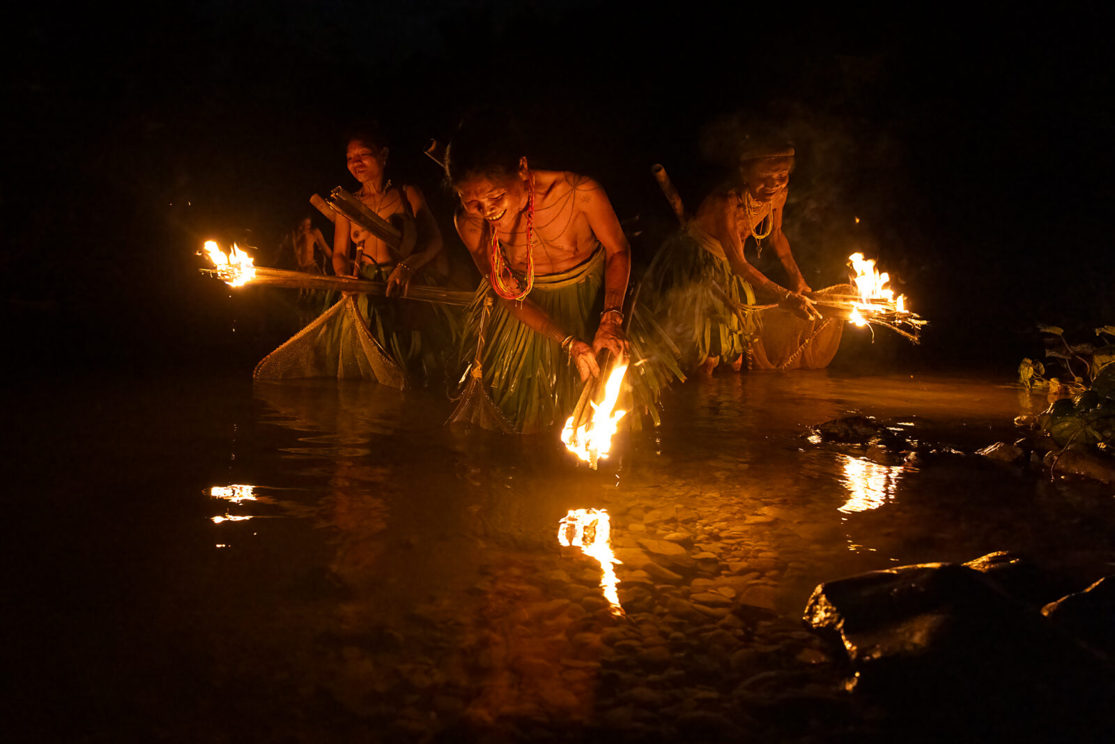 Mentawai women fishing with torches at night
