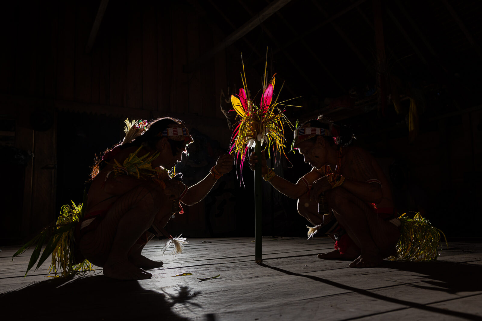 Mentawai shamans with colorful leaves fetish during ceremony on Siberut Island interacting.