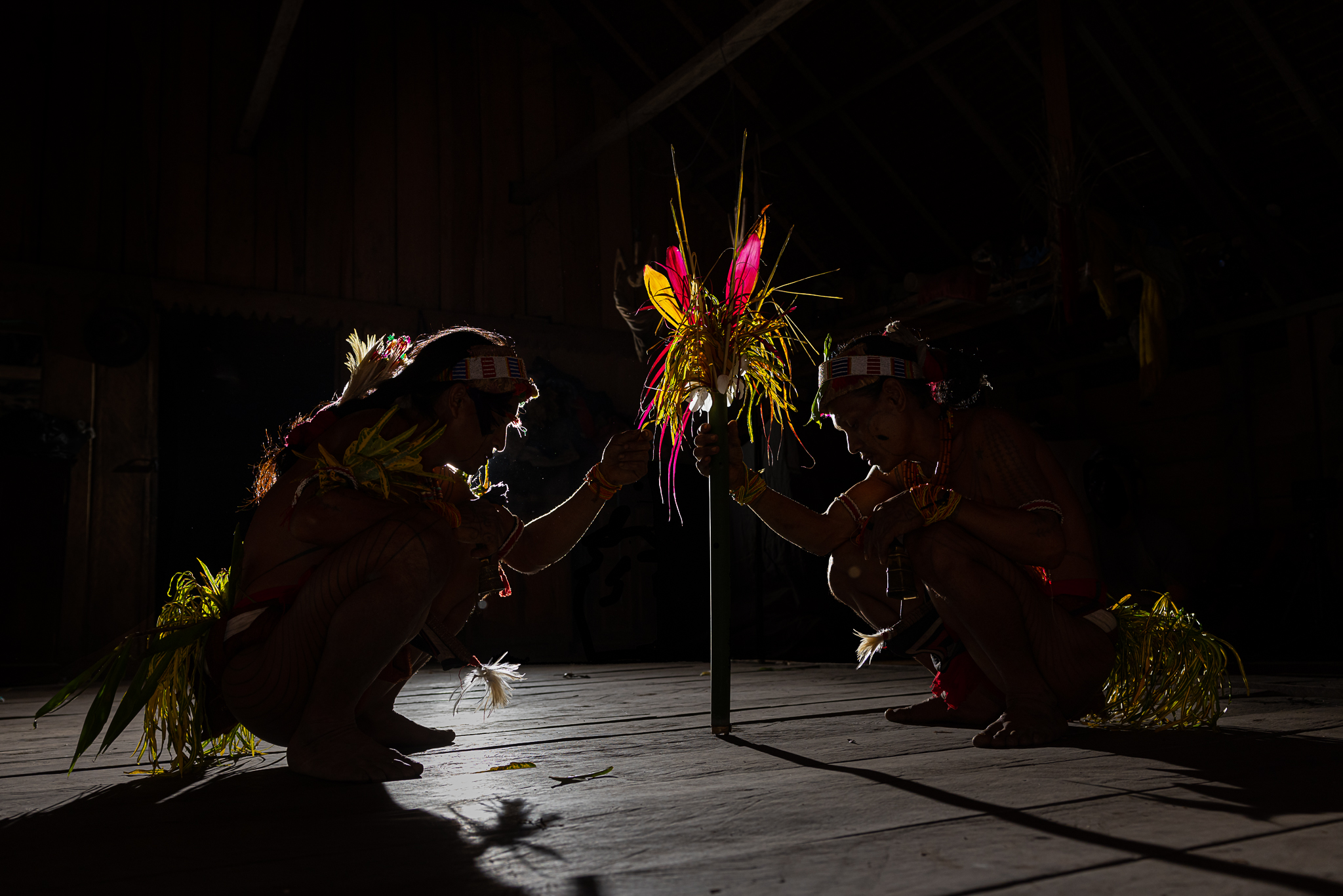 Mentawai shamans with colorful leaves fetish during ceremony on Siberut Island interacting.