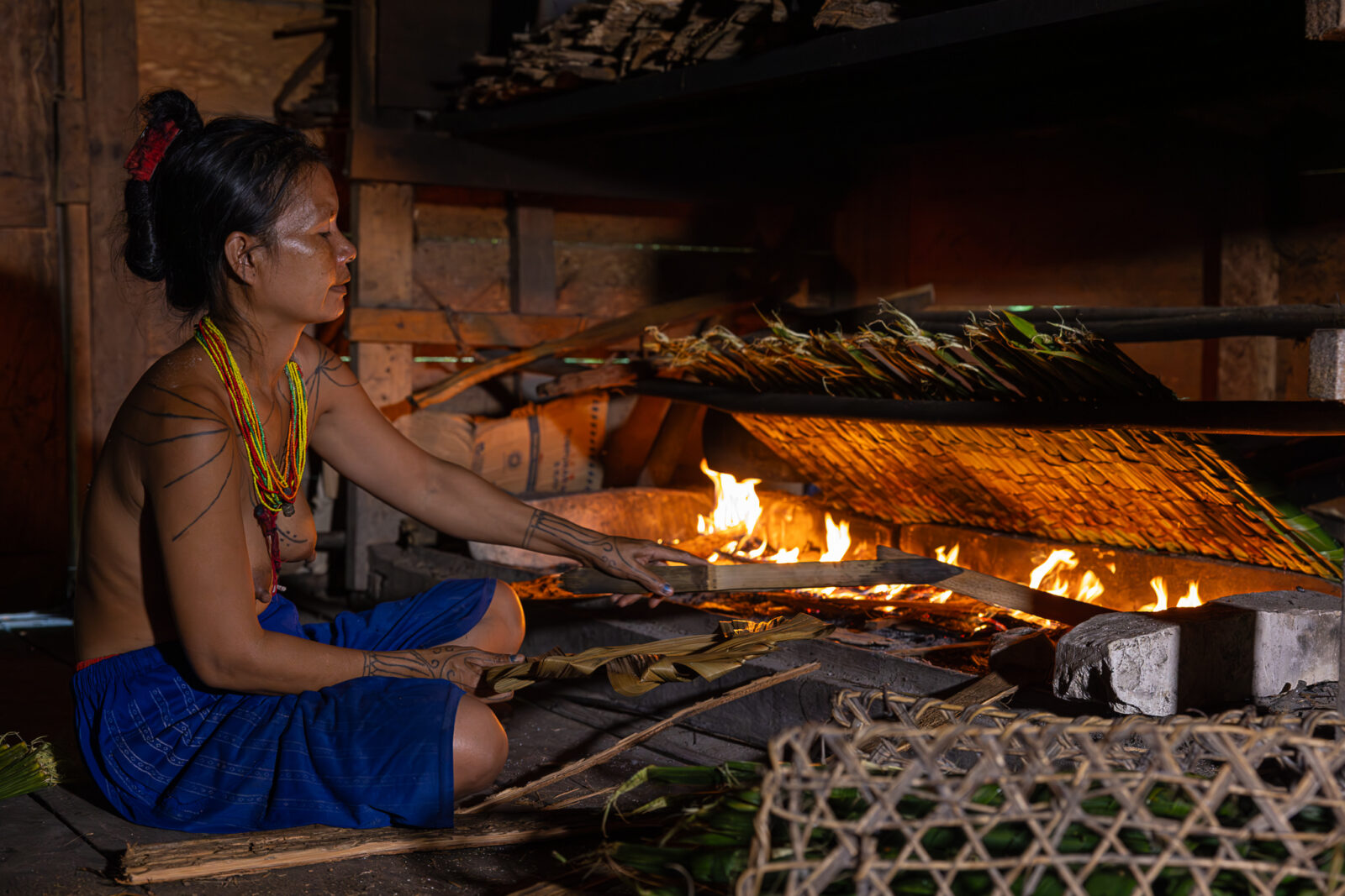 mentawai woman roasting sago sticks