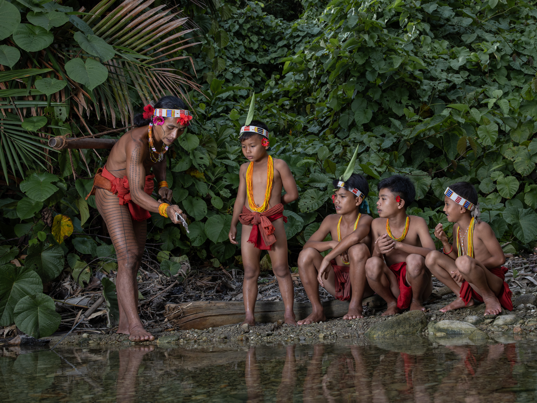 A Mentawai shaman teaching children how to use bow and arrows